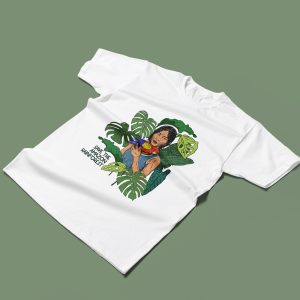 T-shirt bianca streetwear con illustrazione di persona indigena che tiene in braccio un pappagallo colorato tra grandi foglie verdi e scritta “Save the Amazon Rainforest”